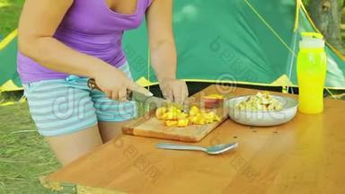 年轻女子在野餐时把<strong>一把</strong>桃刀切成块做水果沙拉。